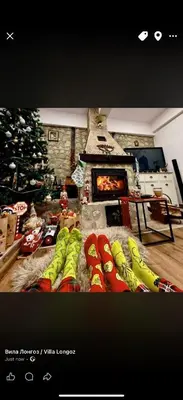 a living room with a christmas tree and a group of snowboards at Вила Лонгоз