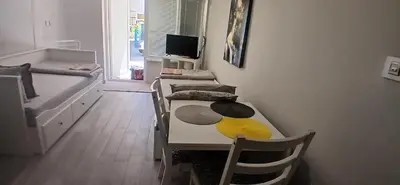 a room with a table and chairs and a bed at Студио за двама в центъра на град Бургас in Burgas City