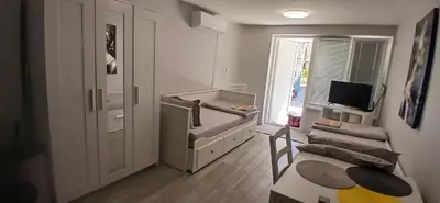 a small white room with a table and a window at Студио за двама в центъра на град Бургас in Burgas City