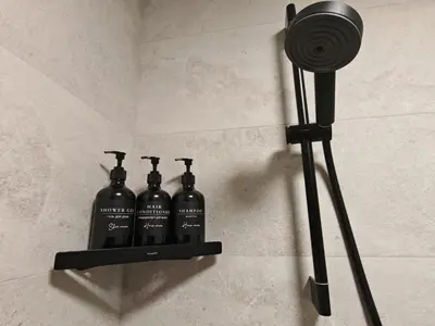 two black bottles on a shelf on a wall at Апартамент Александровска in Burgas City
