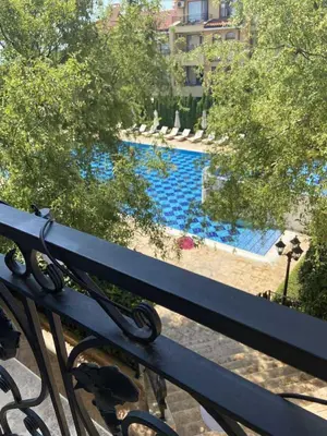 a view of a swimming pool from a bench at Апартамент в затворен комплекс Артур гр Свети Влас in Sveti Vlas
