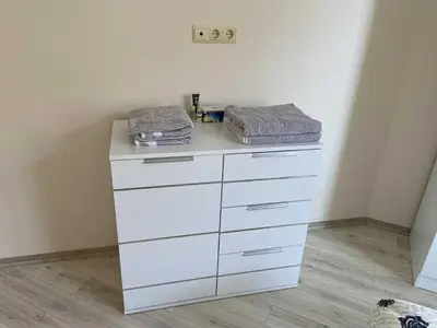 a white dresser in a corner of a room at Апартамент в затворен комплекс Артур гр Свети Влас in Sveti Vlas