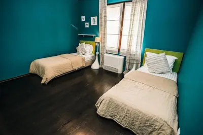 two beds in a room with blue walls and wooden floors at Desing Flat n2 Port - Designer - Own Parking - Streaming - 2 baths - Wash&Dry in Burgas City
