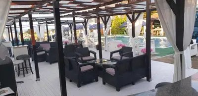 a patio with chairs and a table and a pool at Complex Exotica in Lozenets