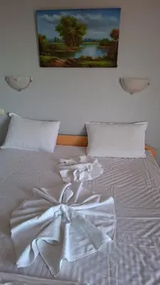 a white bed with a picture on the wall at Complex Exotica in Lozenets