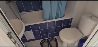 a small bathroom with a toilet and a shower at Seaview apartment with garden & pool in Sunny Beach