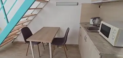 a small kitchen with a wooden table and chairs at Seaview apartment with garden & pool in Sunny Beach