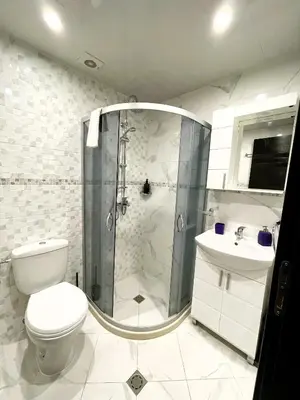 a bathroom with a shower and a toilet and a sink at Velaria Centre Apartment in Burgas City