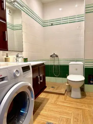 a bathroom with a washing machine and a toilet at Galateya in Varna City