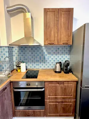 a kitchen with wooden cabinets and a stove top oven at Galateya in Varna City