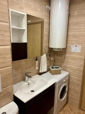 a bathroom with a sink and a washing machine at Luxury Premier Fort Beach in Sveti Vlas