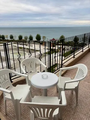 a white table and chairs on a balcony with the ocean at Luxury Premier Fort Beach in Sveti Vlas