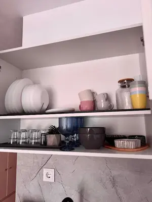 a shelf with plates and bowls and other kitchen items at Studio Sea Breeze Sveti Vlas ap58 in Sveti Vlas