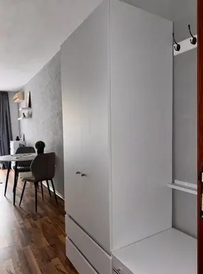 a large white cabinet in a room with a table at Studio Sea Breeze Sveti Vlas ap58 in Sveti Vlas