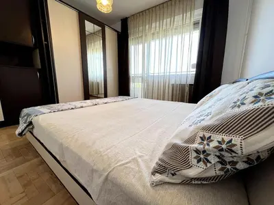 a bedroom with a large bed with a window at Home for you, 2-bedroom apartment in Burgas City