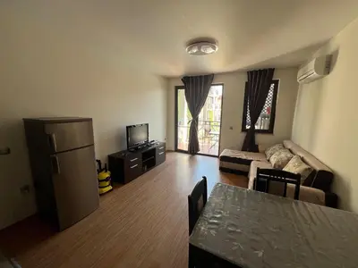 a living room with a couch and a refrigerator and a table at Camping Gradina Sunny Bay Appartment in Chernomorets
