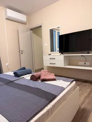 a bedroom with two beds and a flat screen tv at Danny Apartment Welcomes You in Burgas City