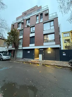 an empty parking lot in front of a brick building at Danny Apartment Welcomes You in Burgas City