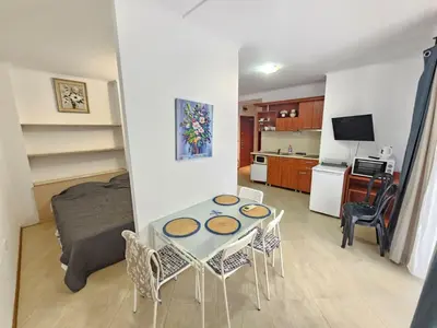 a kitchen and a living room with a table and chairs at PALAZZO FAMILY SUITE Sunny beach in Sunny Beach