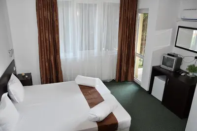 a hotel room with a bed and a tv at Family нouse -Нotel Asai in Ravda