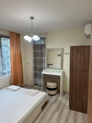 a bedroom with a bed and a desk and a mirror at Apartment near the sea in Pomorie