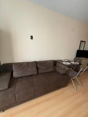 a living room with a brown couch and a table at Sunny day 5 in Tŭnkovo