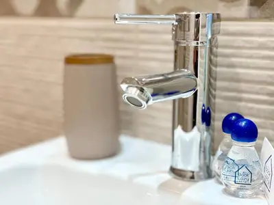 a bathroom sink with a faucet and a bottle of toothpaste at Skyline Loft in Varna City