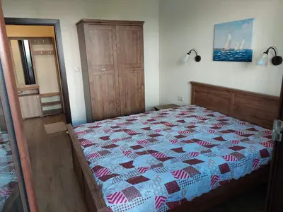 a bedroom with a bed with a quilt on it at Апартаменти Делукс 2 in Burgas City