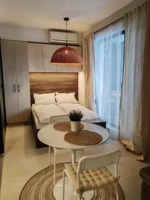 a bedroom with a bed and a table and a table and chairs at SOHO apartments in Burgas City