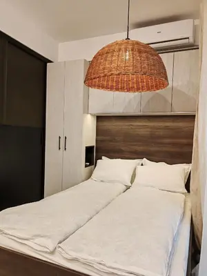 a bedroom with a large bed with a hanging light at SOHO apartments in Burgas City