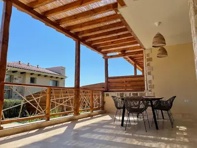 a patio with a table and chairs on a balcony at Lozenets Luxury Pool Villa by Lozenetsvillas in Lozenets