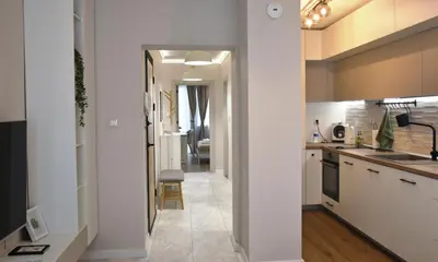 a kitchen with white cabinets and a hallway at Boutique 2-Bedroom Apartment Downtown Burgas in Burgas City