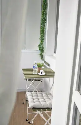 a table and chairs in a room with a window at Boutique 2-Bedroom Apartment Downtown Burgas in Burgas City