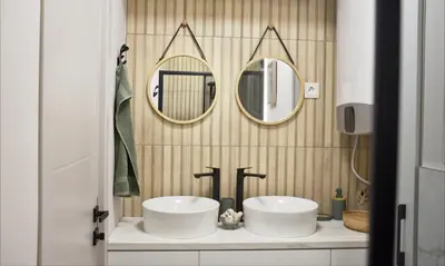 a bathroom with two sinks and two mirrors at Boutique 2-Bedroom Apartment Downtown Burgas in Burgas City