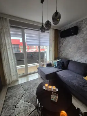 a living room with a couch and a table at Villa Valencja Apartments Family in Sunny Beach
