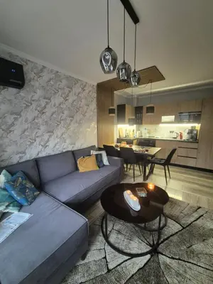 a living room with a blue couch and a table at Villa Valencja Apartments Family in Sunny Beach