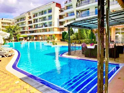 a large swimming pool in front of a building at Grand Kamelia Holiday Apartments Sunny Beach in Sunny Beach