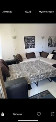 a living room with a table and a couch at Апартаменти Нино 1 in Sozopol