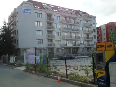 a large building with a fence in front of it at Le studio Summer Breeze in Sunny Beach