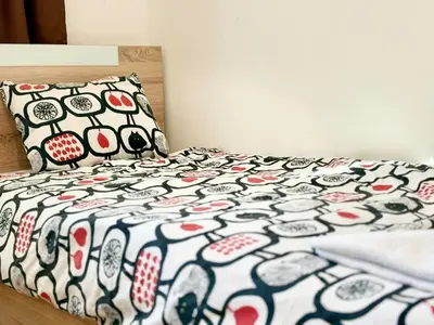 a bed with a black and white comforter and pillows at SeaSide 2BR Central apartment in Varna City