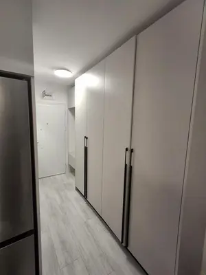 a hallway with white wardrobes and a wall at Yana Sanny Beach in Sunny Beach
