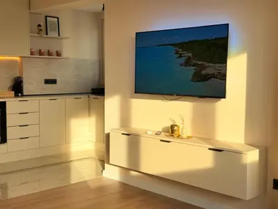 a kitchen with white cabinets and a painting on the wall at Seaside Home in Burgas City