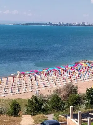 a beach with chairs and umbrellas and the ocean at Apartment for guests Panorama - first line sea in Burgas City