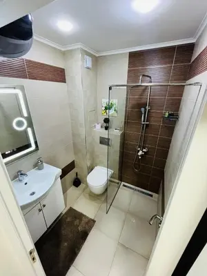 a bathroom with a shower and a toilet and a sink at Apartment for guests Panorama - first line sea in Burgas City