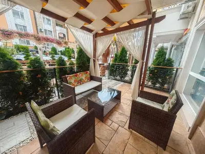 an outdoor patio with chairs and a table at Луксозно Студио Сладък Дом в Слънчев бряг in Sunny Beach
