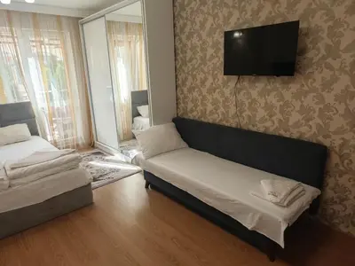 a living room with a couch and a flat screen tv at Луксозно Студио Сладък Дом в Слънчев бряг in Sunny Beach