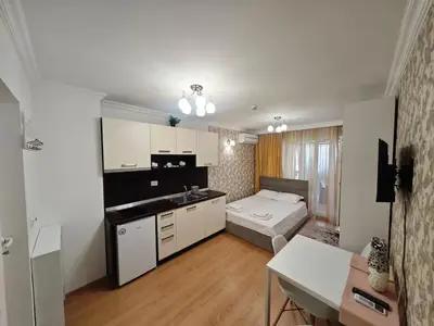 a room with a kitchen and a bed in it at Луксозно Студио Сладък Дом в Слънчев бряг in Sunny Beach