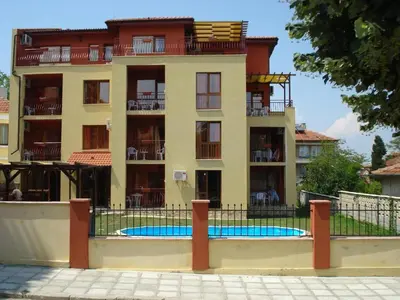 a building with a swimming pool in front of it at Апартамент Park & Sea Retreat in Obzor