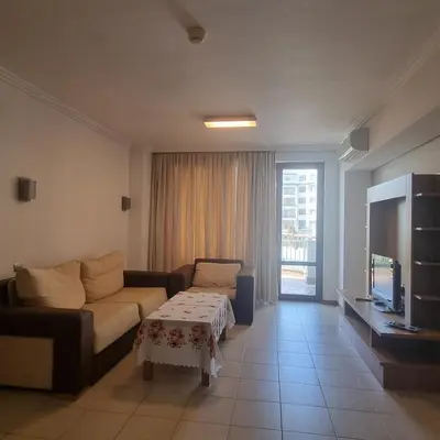 a living room with a couch and a tv at Emerald Beach Resort & Spa, Apartment S105 in Ravda