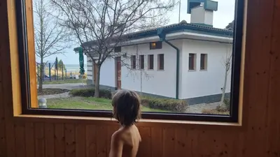a young child looking out of a window at Emerald Beach Resort & Spa, Apartment S105 in Ravda
